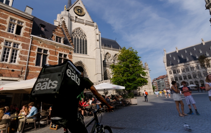 An uber eat delivery boy passing by a square in Leuven, Belgium