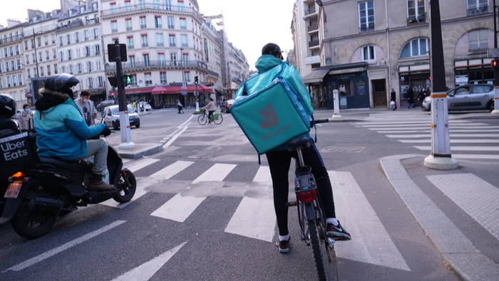 A delivery man during coronavirus pandemic on a bike in the street of Paris.