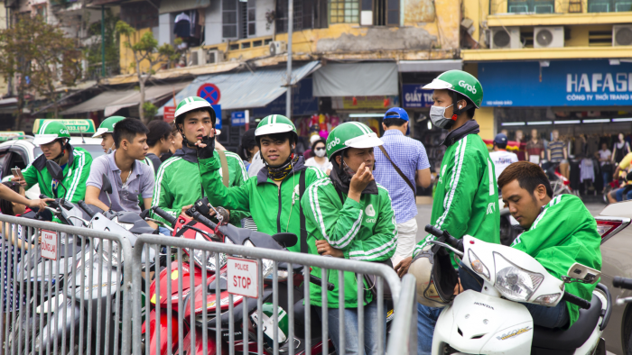 Hanoi, Vietnam - Apr 9, 2017: Vietnamese Grab bike riders waiting for passenger on a street. Grab is a popular app for taxi service in Southeast Asia.